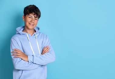 Photo of Portrait of teenage boy on light blue background, space for text