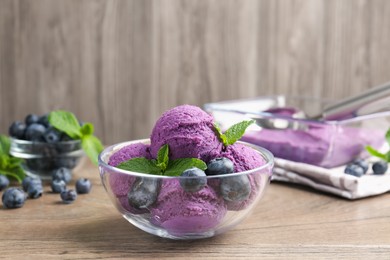 Photo of Tasty sorbet with blueberries and mint on wooden table, closeup