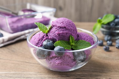 Photo of Tasty sorbet with blueberries and mint on wooden table, closeup