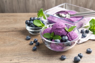 Photo of Tasty sorbet with blueberries and mint on wooden table, closeup. Space for text