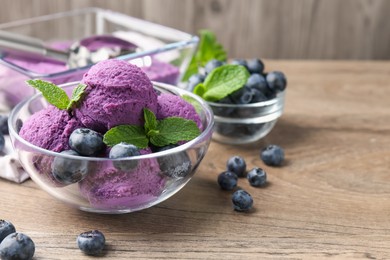 Photo of Tasty sorbet with blueberries and mint on wooden table, closeup. Space for text
