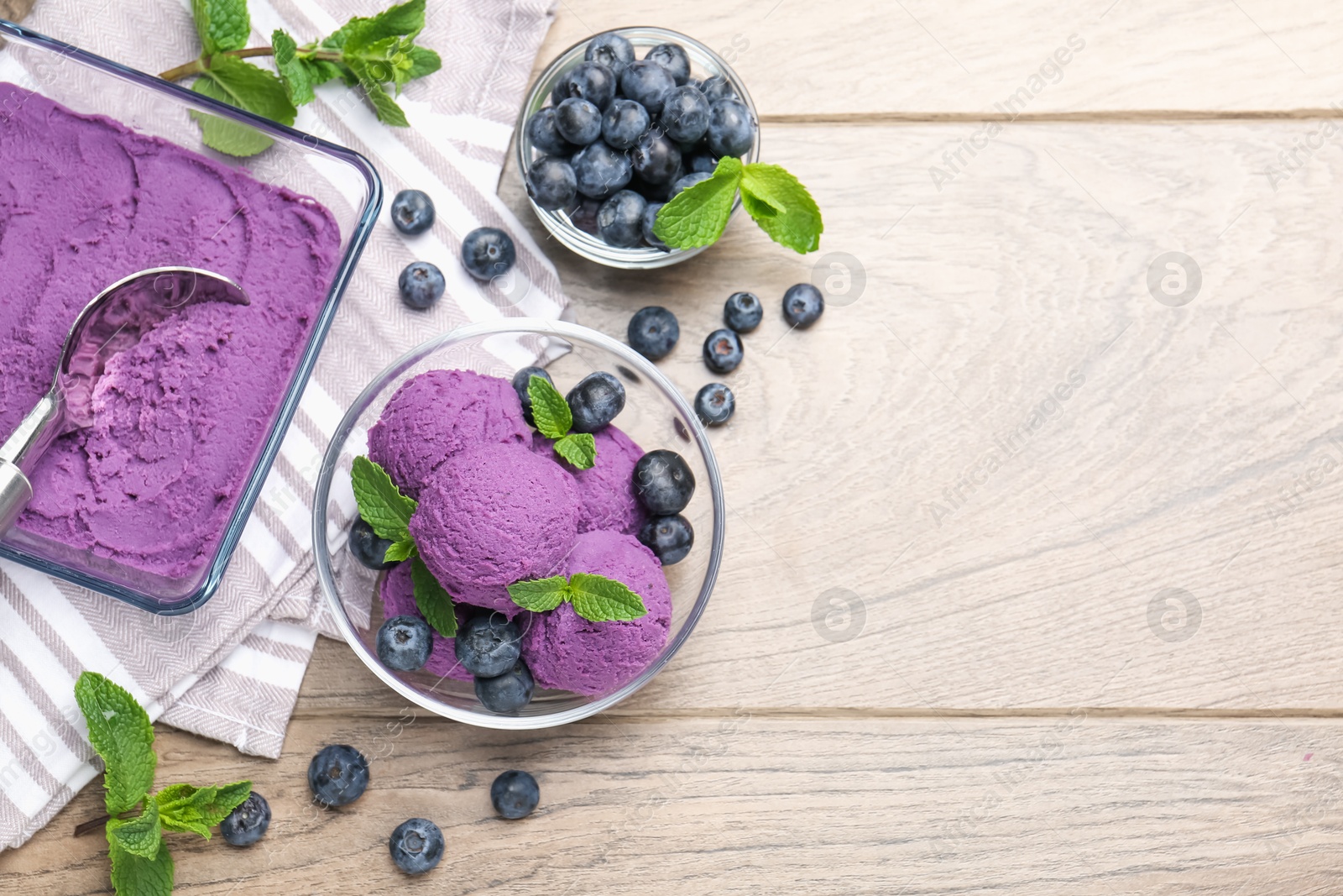 Photo of Tasty sorbet with blueberries and mint on wooden table, flat lay. Space for text