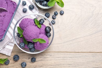 Photo of Tasty sorbet with blueberries and mint on wooden table, flat lay. Space for text