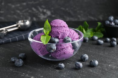 Photo of Tasty sorbet with blueberries and mint on black table, closeup