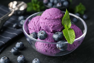 Photo of Tasty sorbet with blueberries and mint on black table, closeup