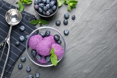 Photo of Tasty sorbet with blueberries and mint on black table, flat lay. Space for text