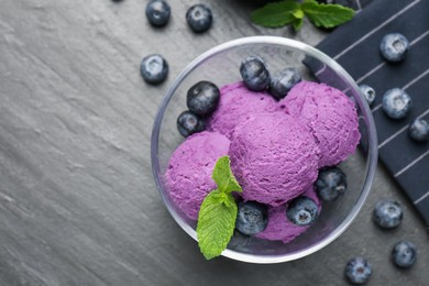 Photo of Tasty sorbet with blueberries and mint on black table, flat lay. Space for text