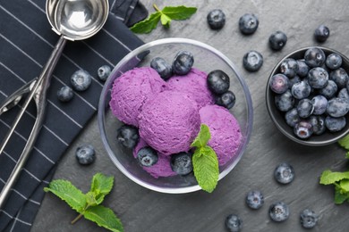 Photo of Tasty sorbet with blueberries and mint on black table, flat lay