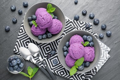 Photo of Tasty sorbet with blueberries and mint on black table, flat lay