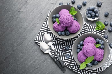 Photo of Tasty sorbet with blueberries and mint on black table, flat lay. Space for text