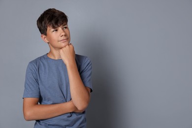 Photo of Portrait of teenage boy on grey background, space for text