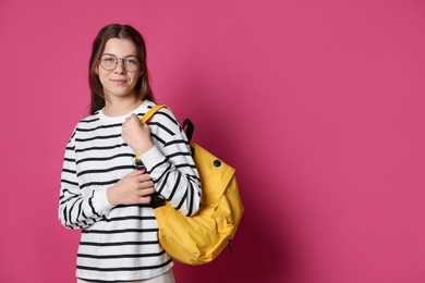 Photo of Teenage girl in glasses with backpack on crimson background, space for text