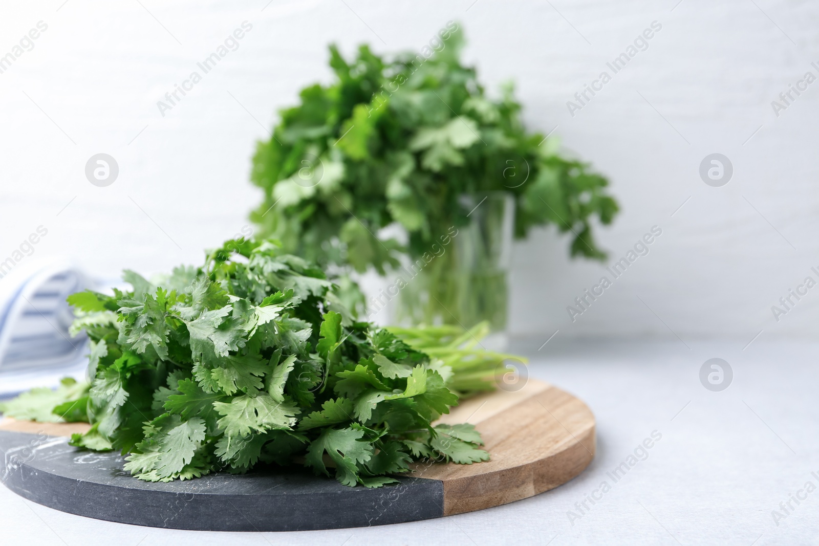 Photo of Fresh green cilantro on light table, closeup. Space for text