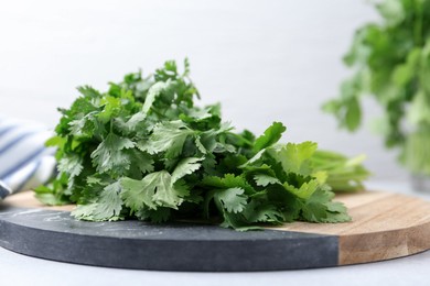 Photo of Fresh green cilantro on light table, closeup