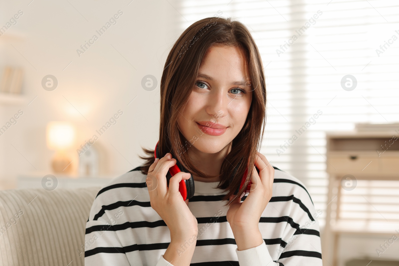 Portrait of beautiful teenage girl with headphones at home Photo of Portrait of beautiful teenage girl with headphones at home