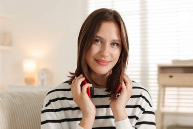 Photo of Portrait of beautiful teenage girl with headphones at home