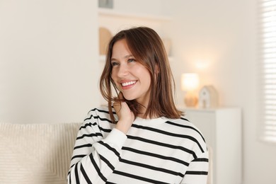 Photo of Smiling teenage girl on sofa at home