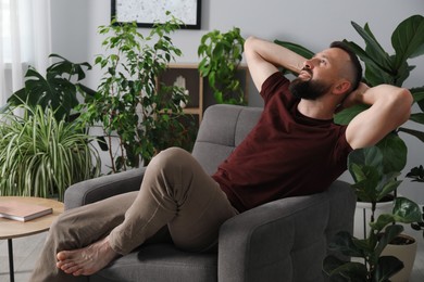 Photo of Harmony. Man relaxing in comfortable armchair at home
