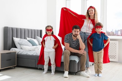 Photo of Portrait of parents and children in superhero costumes at home