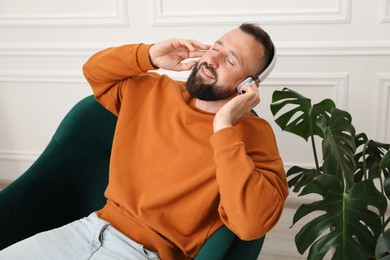 Photo of Harmony. Man listening to music in headphones at home