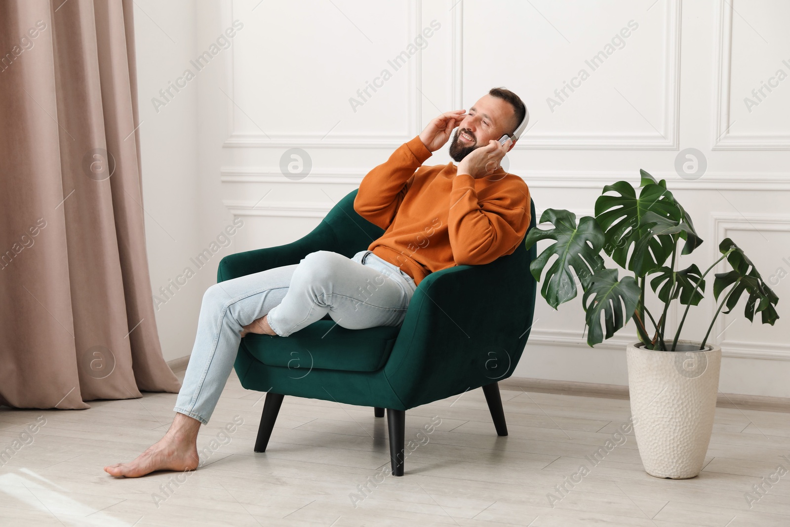 Harmony. Man listening to music in headphones at home Photo of Harmony. Man listening to music in headphones at home