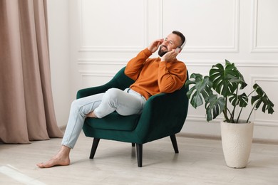 Photo of Harmony. Man listening to music in headphones at home