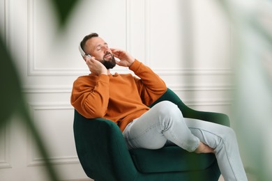 Photo of Harmony. Man listening to music in headphones at home