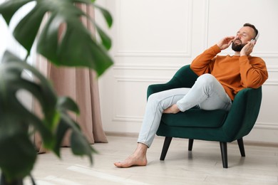Photo of Harmony. Man listening to music in headphones at home