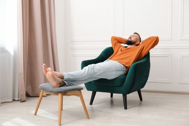 Photo of Harmony. Man relaxing in comfortable armchair at home