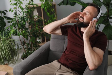 Photo of Harmony. Man listening to music in headphones at home