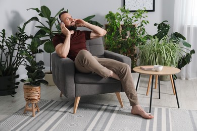 Photo of Harmony. Man listening to music in headphones at home