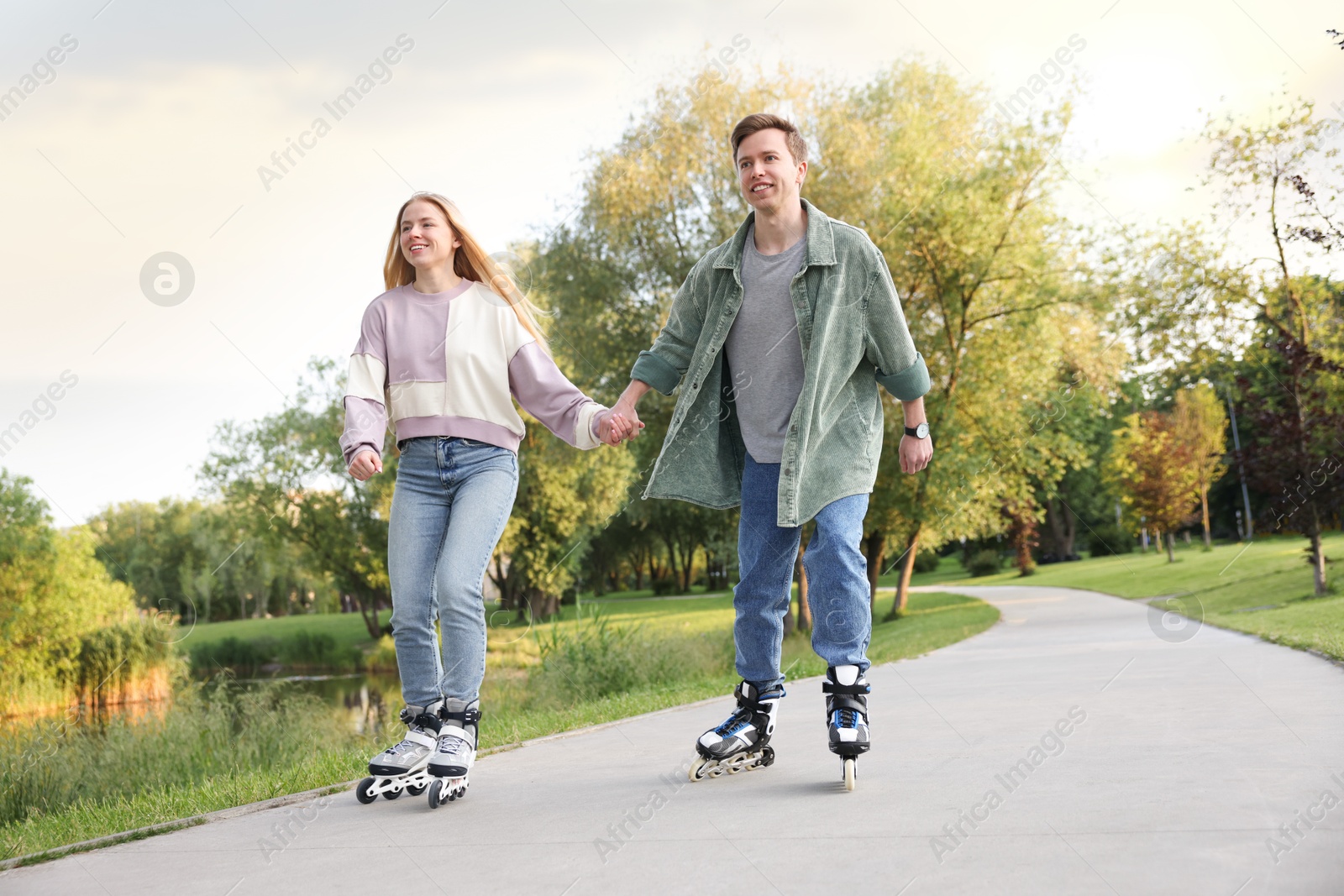 Happy couple roller skating together in park Photo of Happy couple roller skating together in park