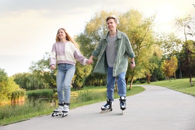 Photo of Happy couple roller skating together in park