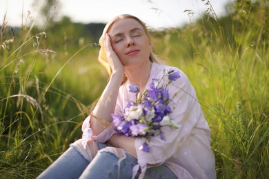 Photo of Beautiful woman with bouquet of wildflowers in meadow