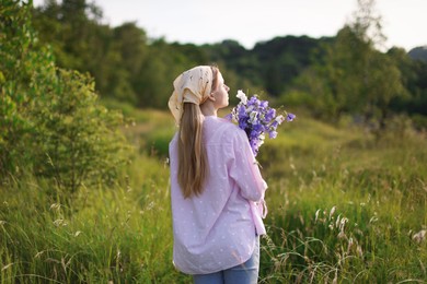 Photo of Beautiful woman with bouquet of wildflowers in meadow on sunny day