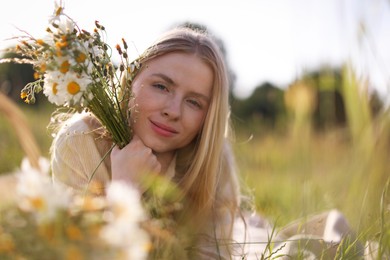 Photo of Beautiful woman with wildflowers in meadow on sunny day