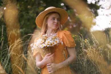 Photo of Beautiful woman with bouquet of wildflowers in meadow