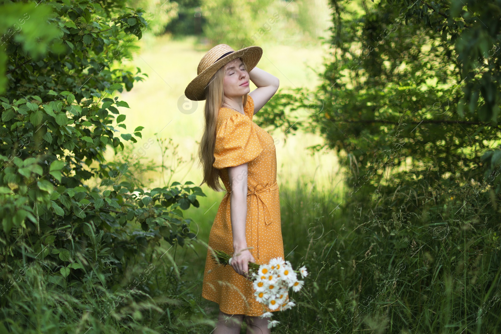 Beautiful woman with bouquet of wildflowers in forest Photo of Beautiful woman with bouquet of wildflowers in forest
