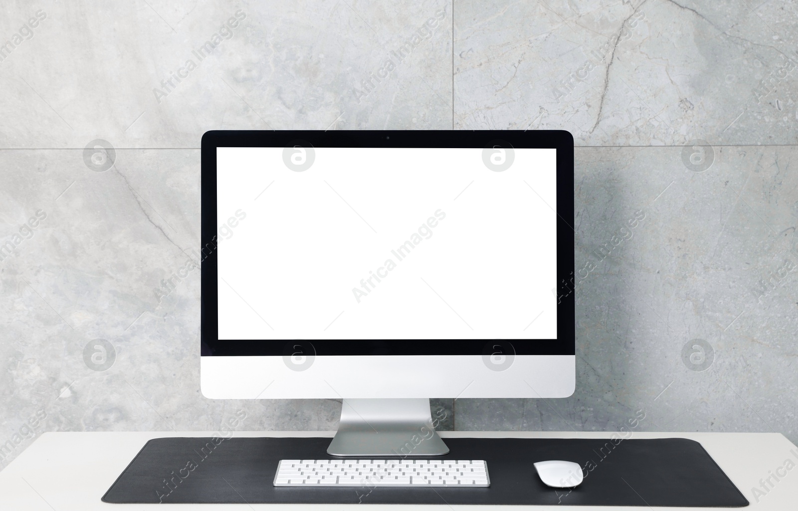 Photo of Stylish workplace with computer and black mousepad on white table indoors. Space for text