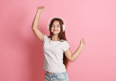 Photo of Teenage girl in headphones on pink background