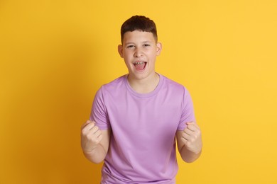 Photo of Portrait of teenage boy on orange background