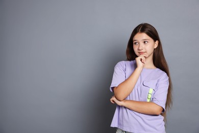 Photo of Portrait of teenage girl on grey background, space for text