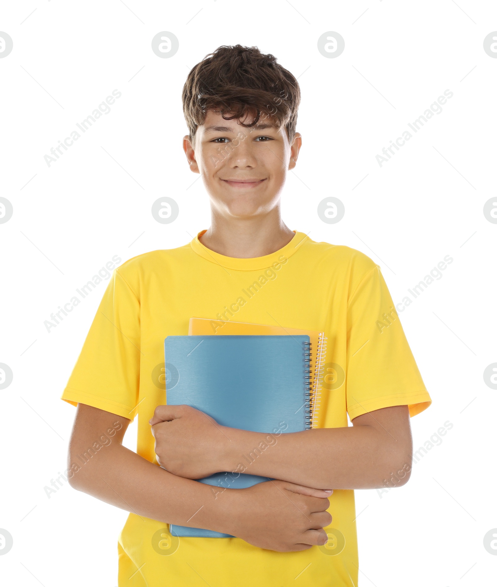 Teenage boy with notebooks on white background Photo of Teenage boy with notebooks on white background