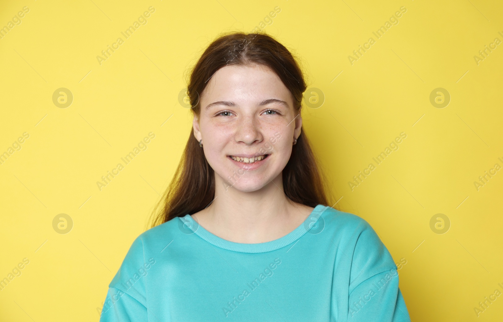 Portrait of teenage girl on yellow background Photo of Portrait of teenage girl on yellow background