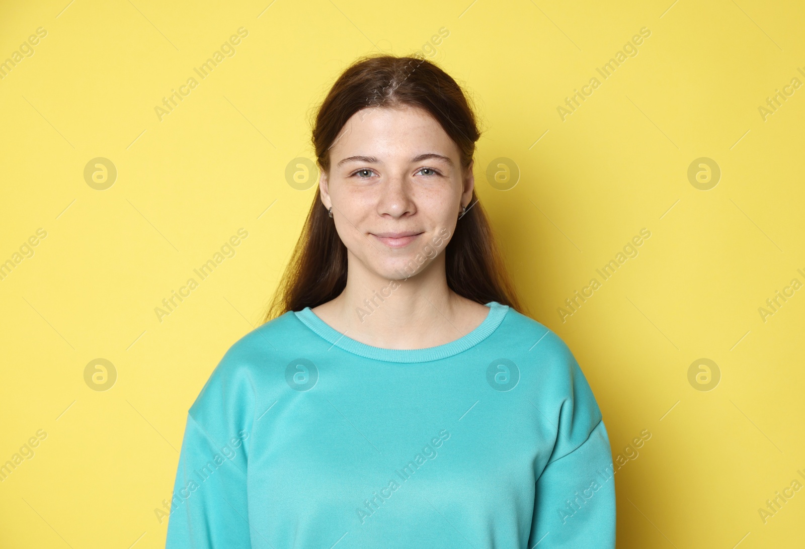 Portrait of teenage girl on yellow background Photo of Portrait of teenage girl on yellow background