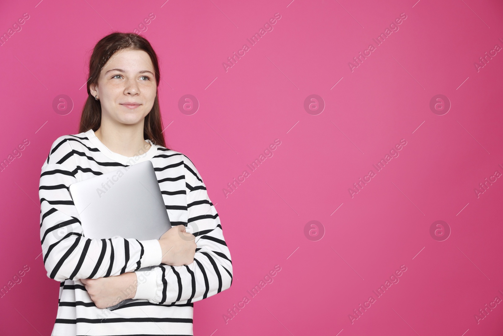 Photo of Teenage girl with laptop on crimson background, space for text
