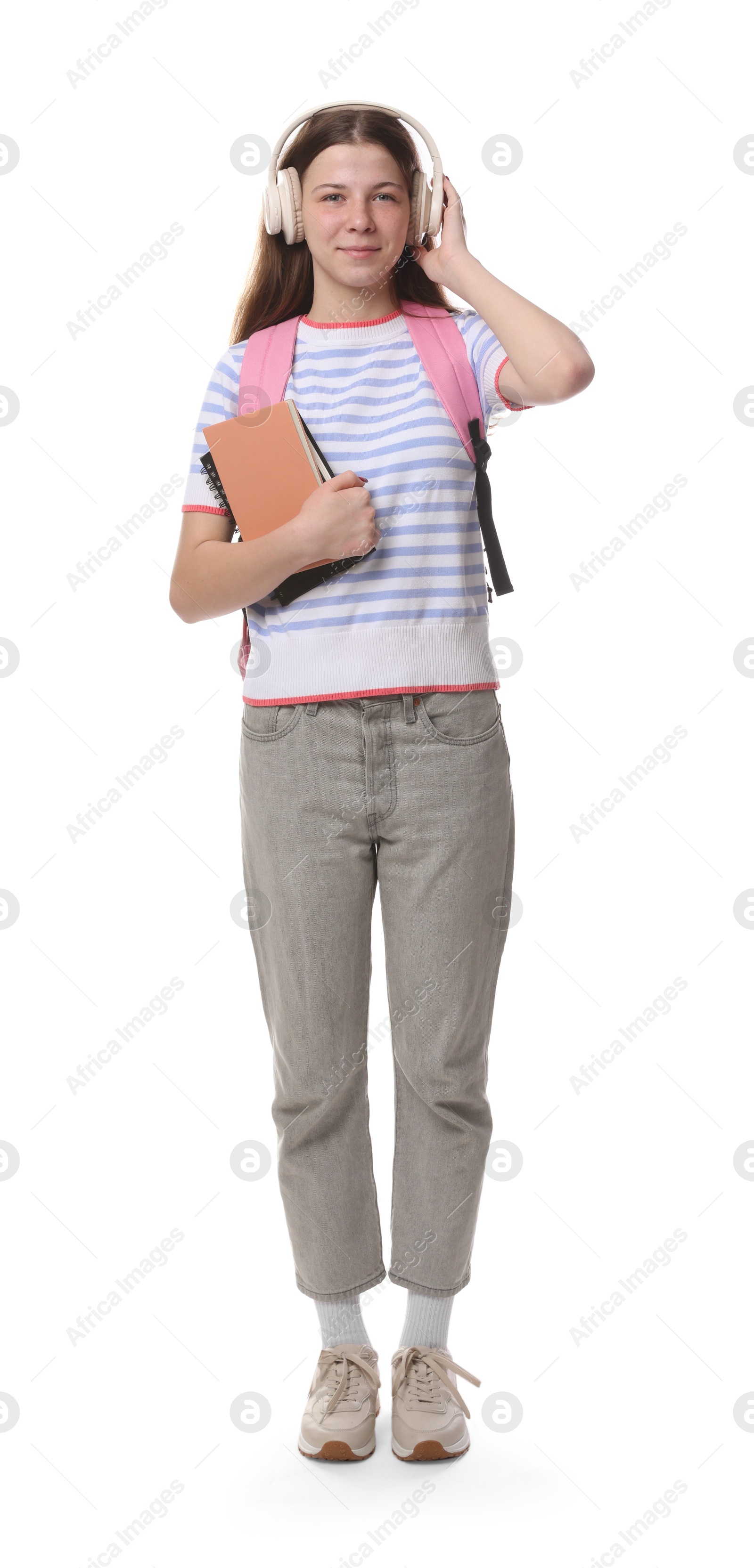 Teenage girl in headphones with backpack and notebooks on white background Photo of Teenage girl in headphones with backpack and notebooks on white background