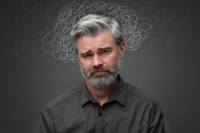 Image of Upset man on grey background. Confused thoughts as doodles around his head. Stress, anxiety, depression