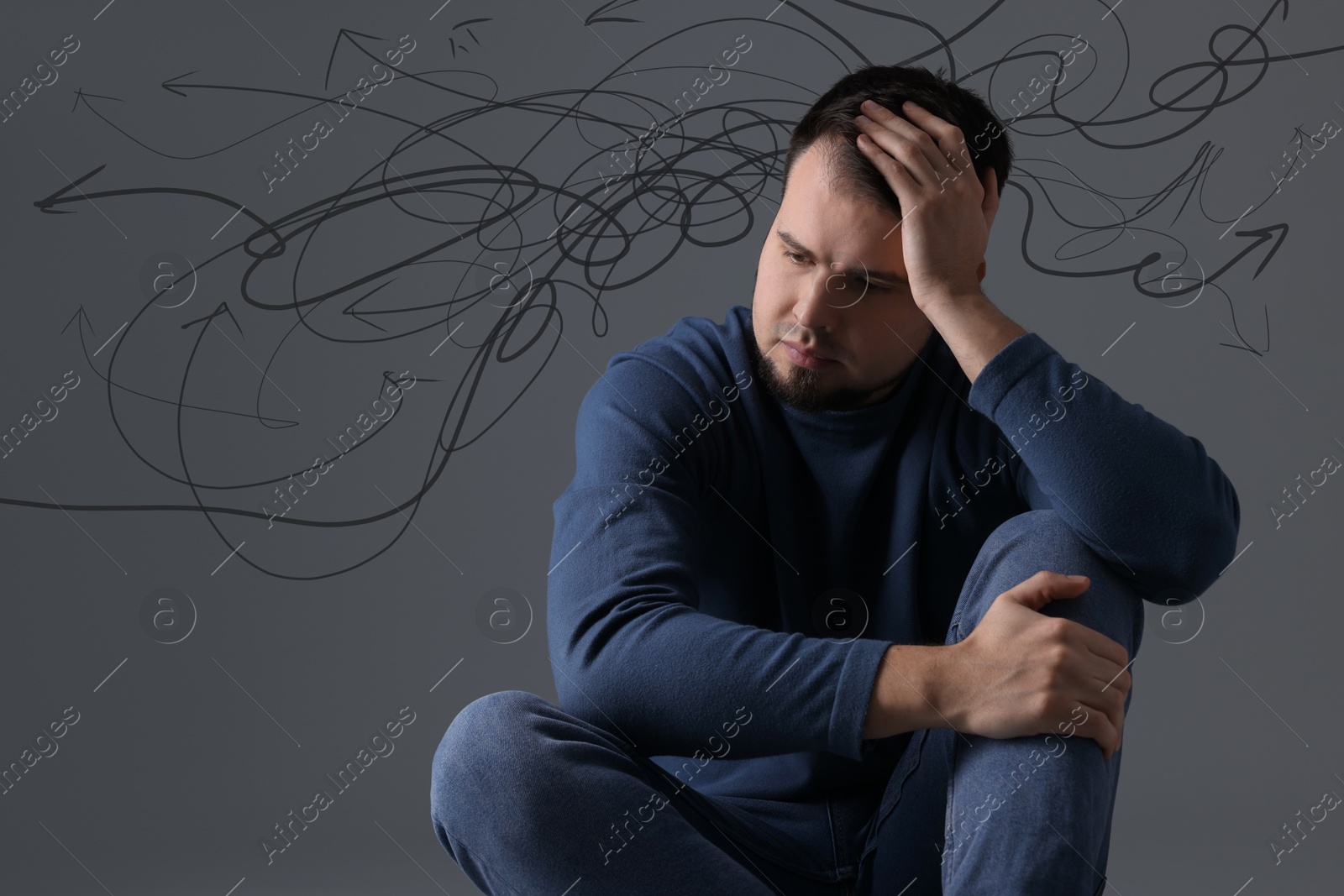 Image of Worried man on grey background. Confused thoughts as doodles coming out of his head. Stress, anxiety, depression