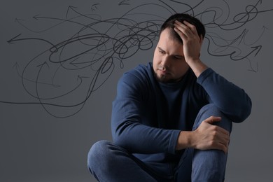 Image of Worried man on grey background. Confused thoughts as doodles coming out of his head. Stress, anxiety, depression
